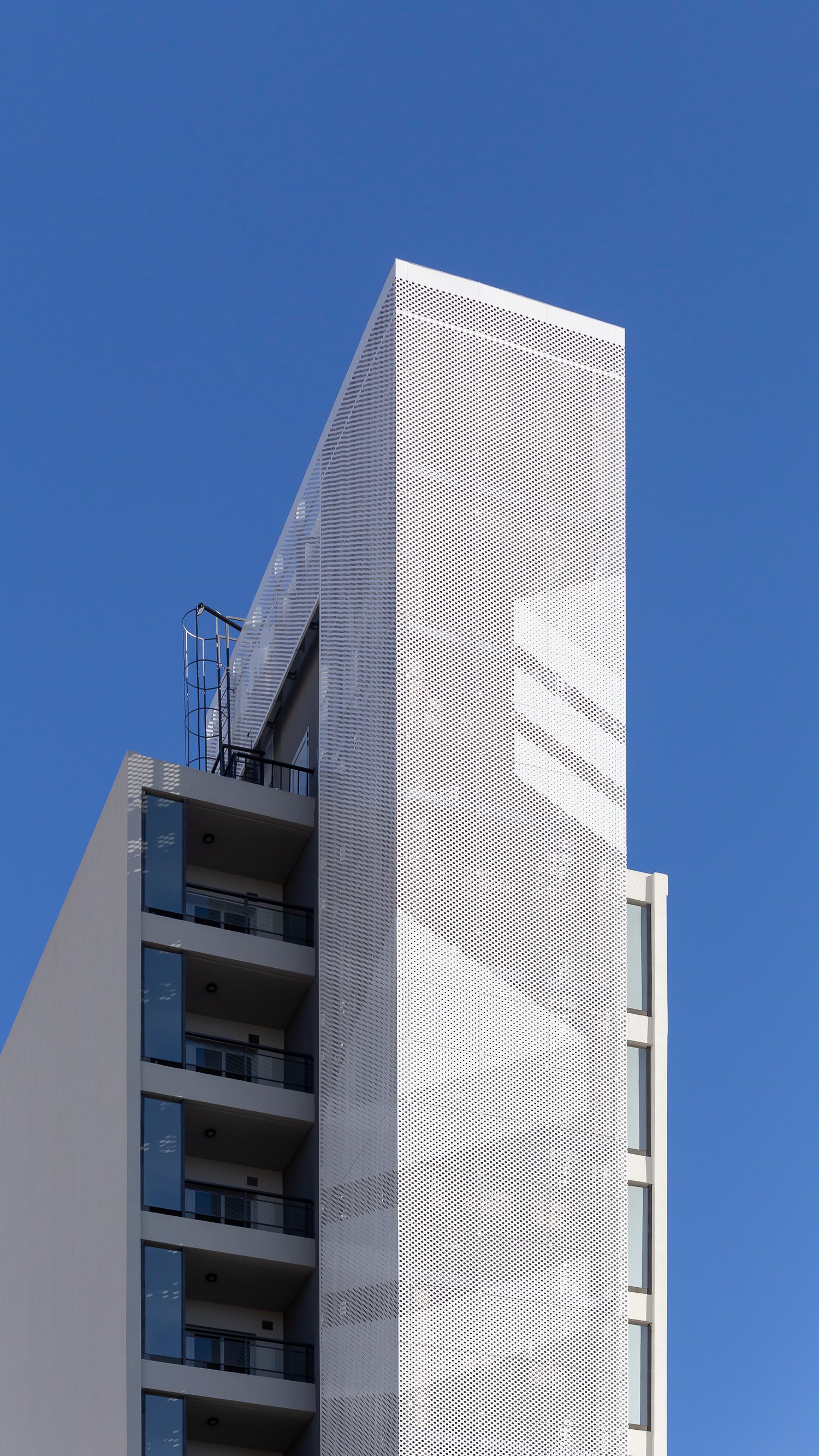 Torre CAM Venecia envuelta en piel metálica perforada contra el cielo